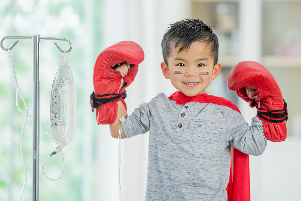 Ein krebskranker Junge mit Boxhandschuhen an